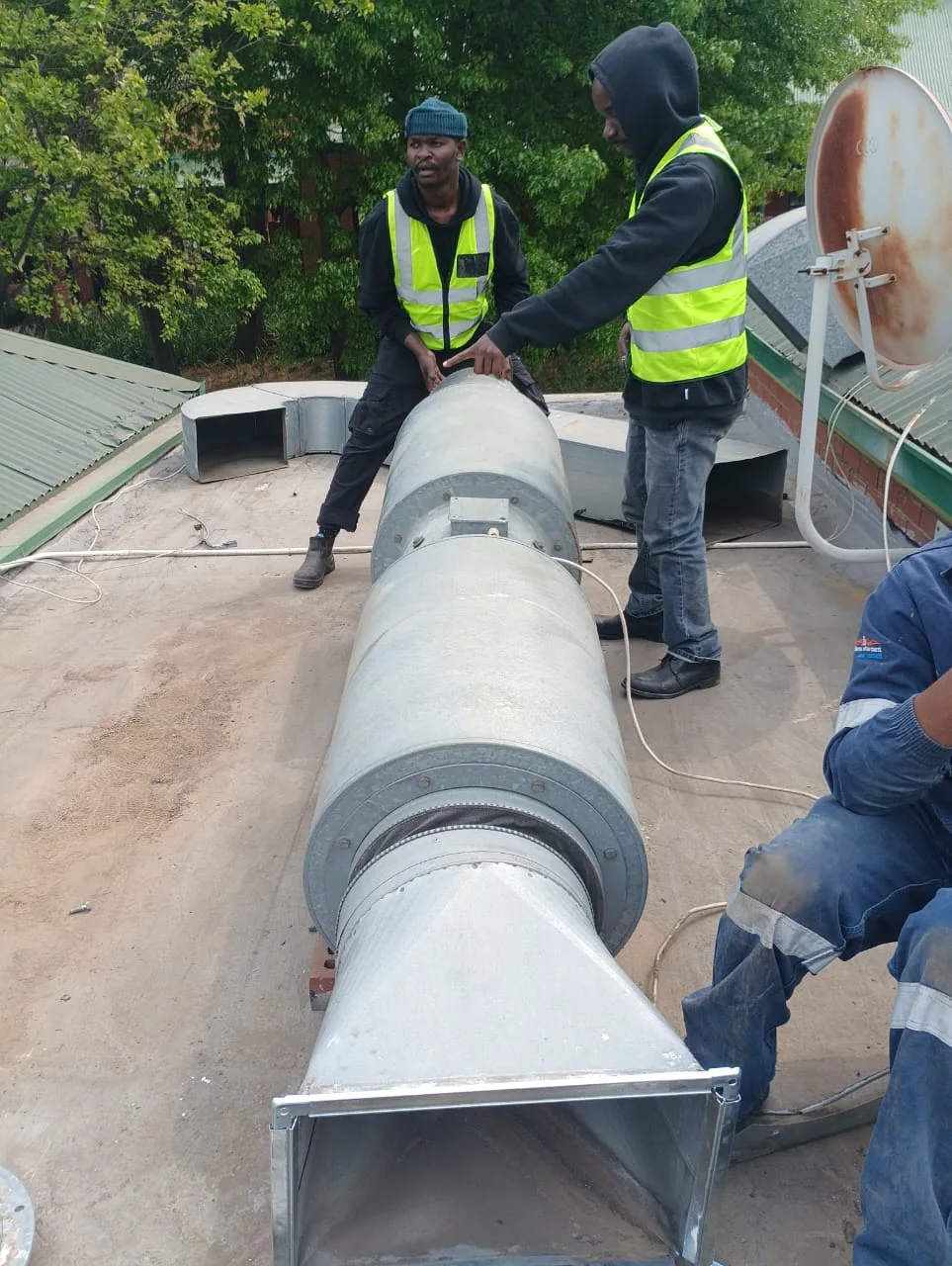 Technicians assembling rooftop extractor ductwork