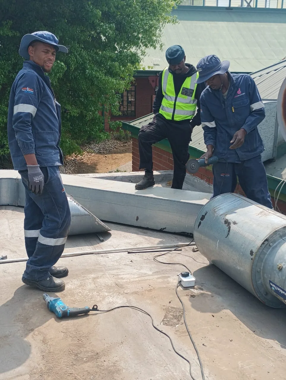 Technicians cutting and repairing ventilation ductwork