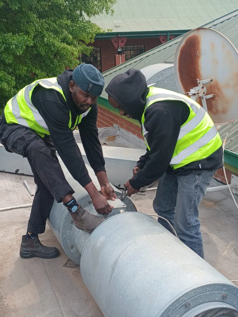 Technicians fastening a ventilation duct connection