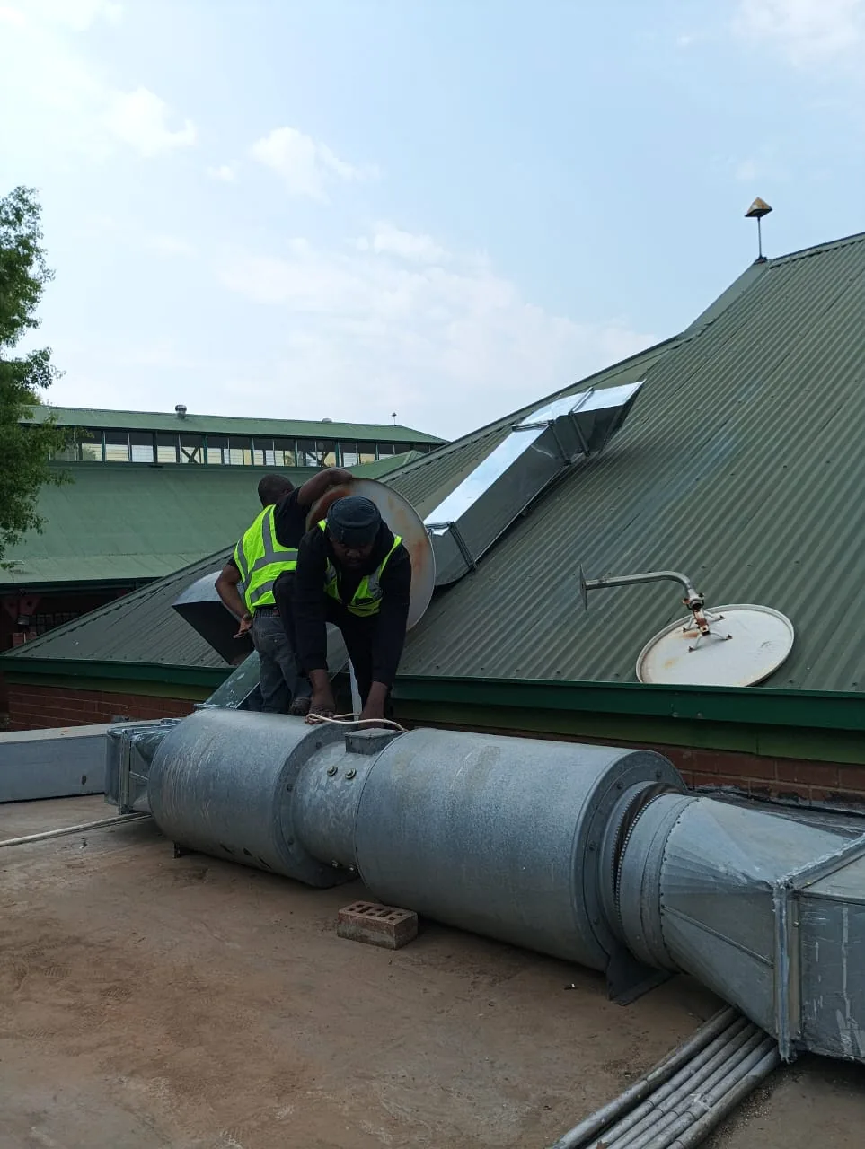 Technician working on rooftop extractor ducting